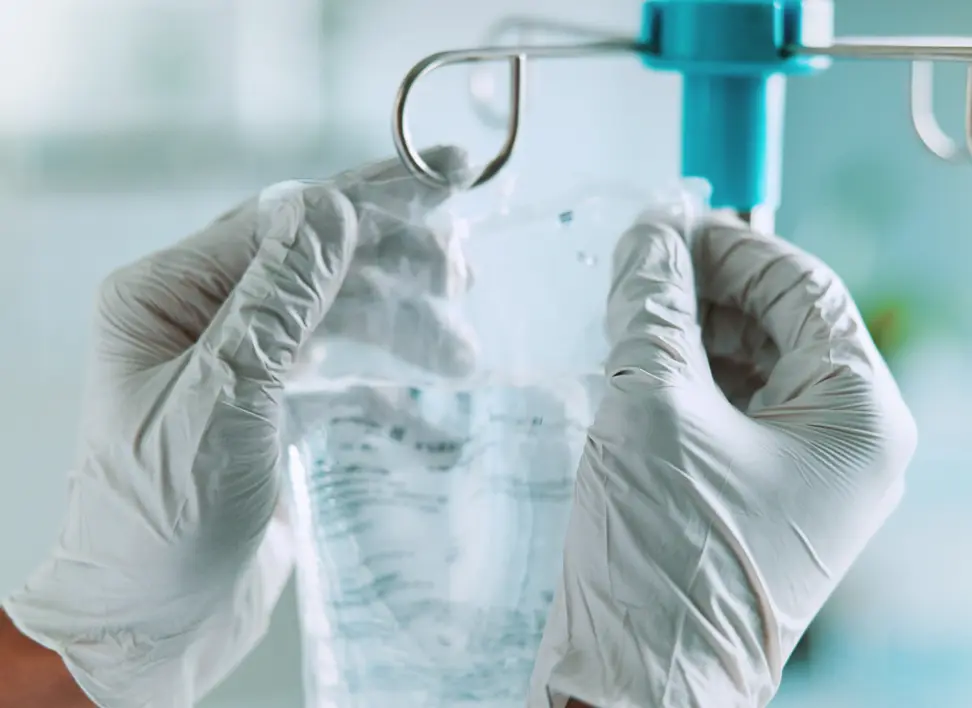 Clinician preparing a ketamine IV drip for a monitored infusion