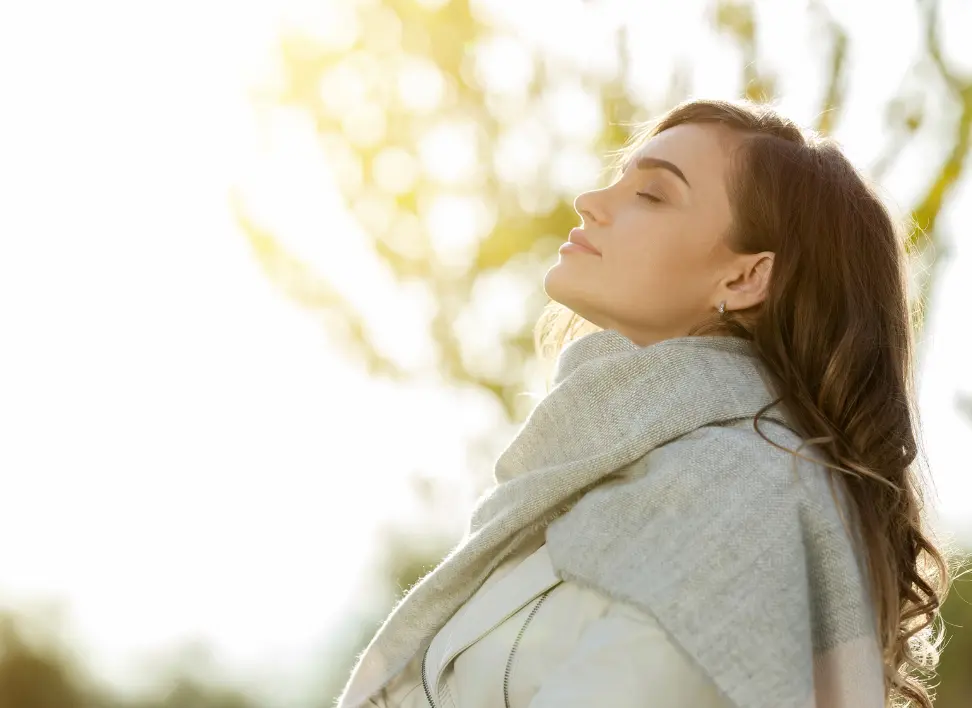 Woman outdoors feeling calmer after ketamine therapy for chronic pain and depression.