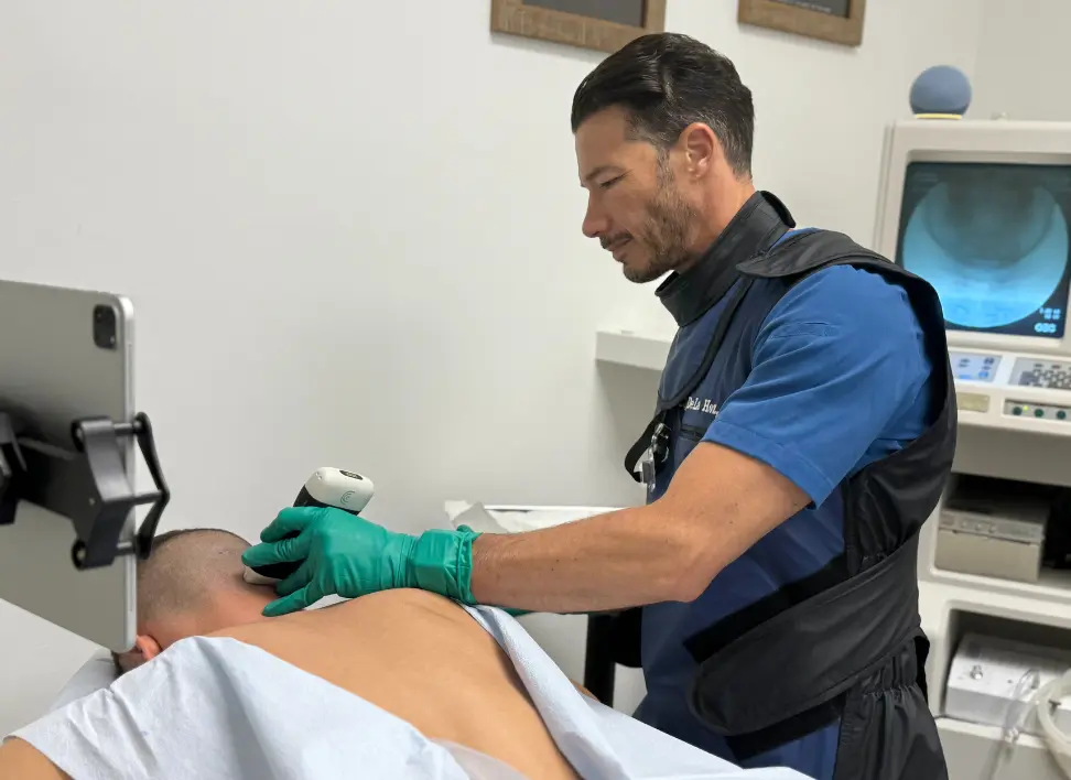 Dr. Carlos De La Hoz performing regenerative therapy on patient to support tissue healing and recovery
