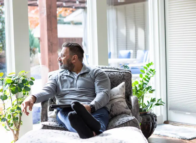 Man sitting at home feeling low energy, a common symptom of low testosterone levels