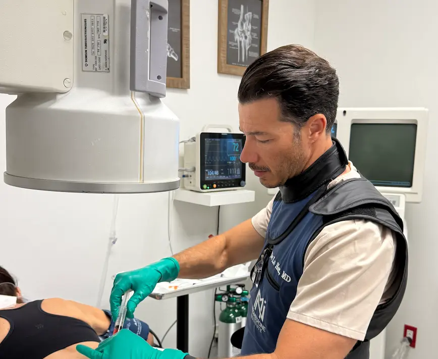 Dr. Carlos De La Hoz performing a stem cell injection on a patient at his clinic in Miami