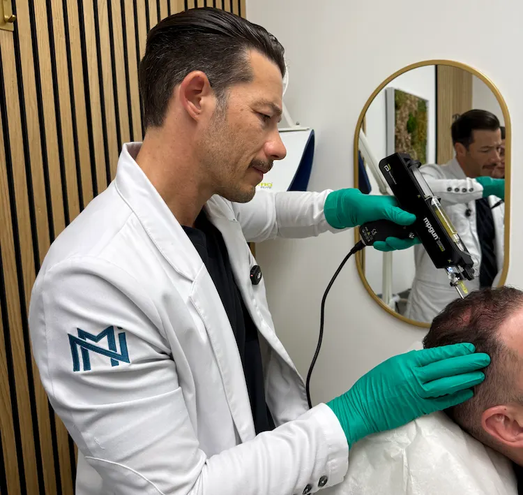 Dr. Carlos De La Hoz, MD performing hair prp on a patient